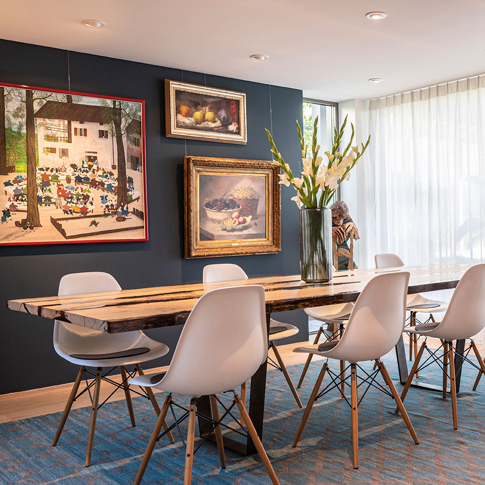 Ein elegantes Esszimmer-Design, das mit einem modernen Farbdesign und stilvollem Interiordesign überzeugt. Der ikonische Eames Chair fügt dem Raum ein zeitloses Element hinzu und harmoniert perfekt mit den natürlichen Materialien, wie dem Esstisch aus charakteristischen Briccole-Elementen aus Venedig, der als markanter Akzent im Raum dient. Die Wahl der Wandfarb verstärkt die gemütliche und doch raffinierte Atmosphäre. Das Farbdesign sorgt für eine stimmige Verbindung zwischen den Möbelstücken und der Umgebung und schafft ein harmonisches Gesamtbild, das sowohl Tradition als auch Moderne widerspiegelt.